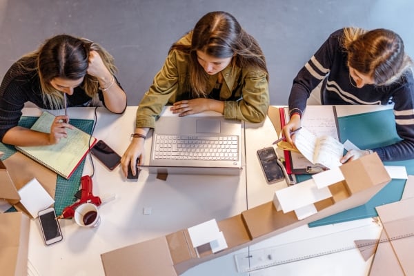 Architecture students study on their own in the classroom, reflecting on the changing dynamics of student engagement in higher education.
