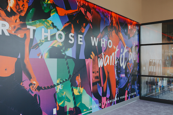 The mural at TruFusion Foundry's entrance promotes well-being and community spirit.